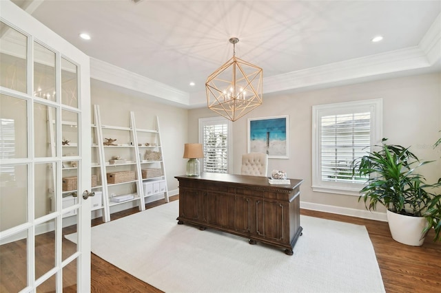 office featuring a raised ceiling, an inviting chandelier, ornamental molding, and hardwood / wood-style flooring