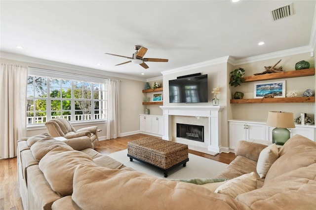 living room featuring crown molding, ceiling fan, and light wood-type flooring