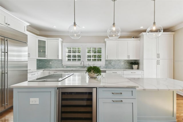 kitchen with wine cooler, white cabinetry, a kitchen island, hanging light fixtures, and built in fridge