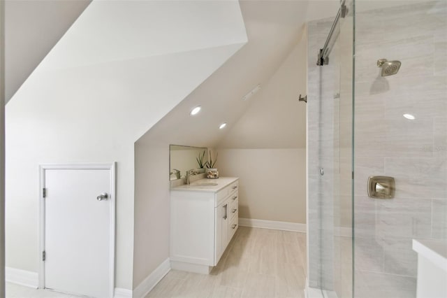 bathroom featuring lofted ceiling, vanity, and a shower with shower door