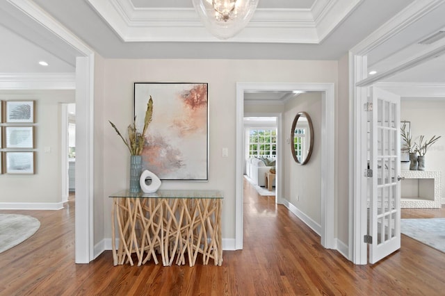 hall with ornamental molding, wood finished floors, and baseboards