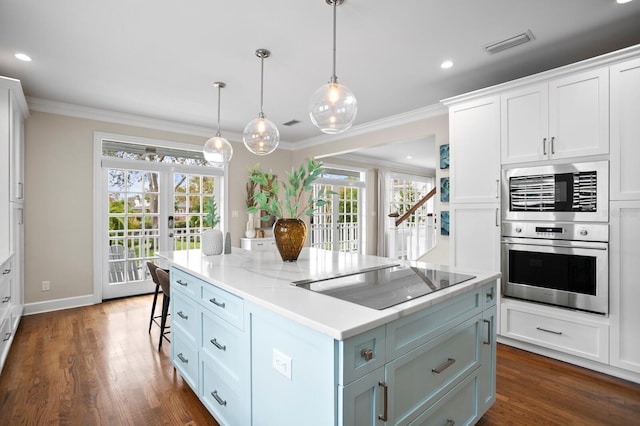 kitchen featuring hanging light fixtures, a kitchen island, white cabinetry, and black electric cooktop