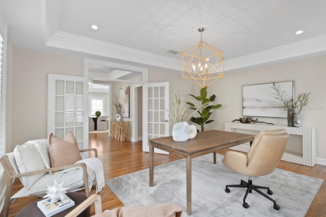 office space with baseboards, a raised ceiling, ornamental molding, wood finished floors, and recessed lighting