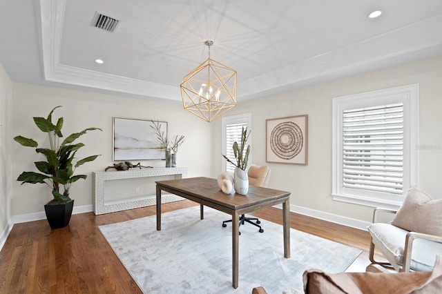 office area with a raised ceiling, baseboards, and wood finished floors