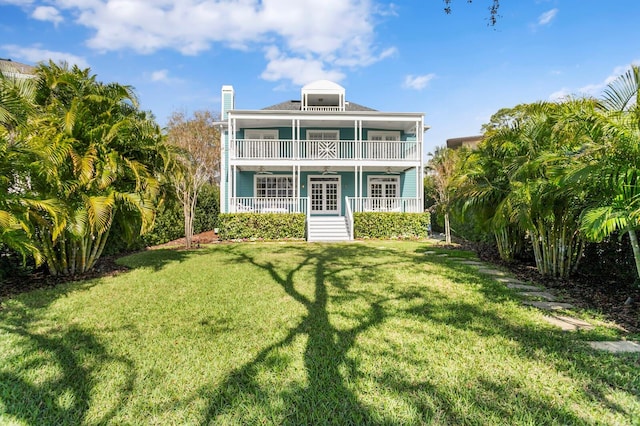 back of house with french doors, a yard, and a balcony