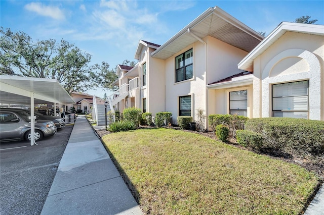 view of side of property with a carport and a yard