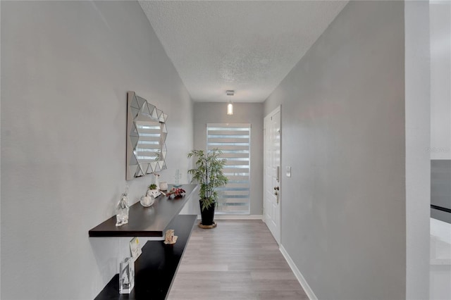 doorway to outside featuring a textured ceiling and light wood-type flooring