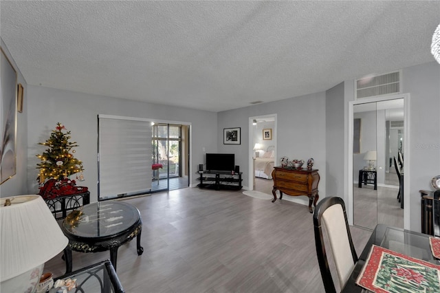 living room with a textured ceiling and light hardwood / wood-style floors