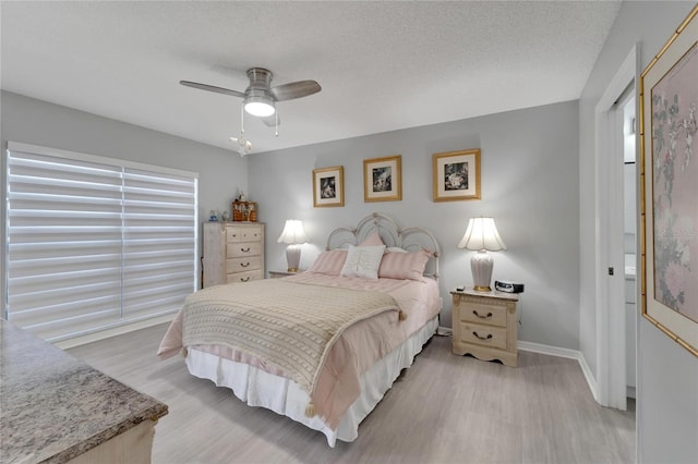 bedroom with ceiling fan, a textured ceiling, and light wood-type flooring