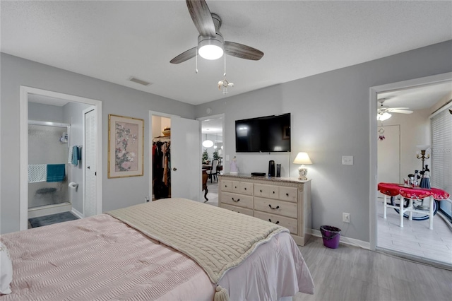 bedroom featuring a walk in closet, ceiling fan, connected bathroom, light hardwood / wood-style floors, and a closet