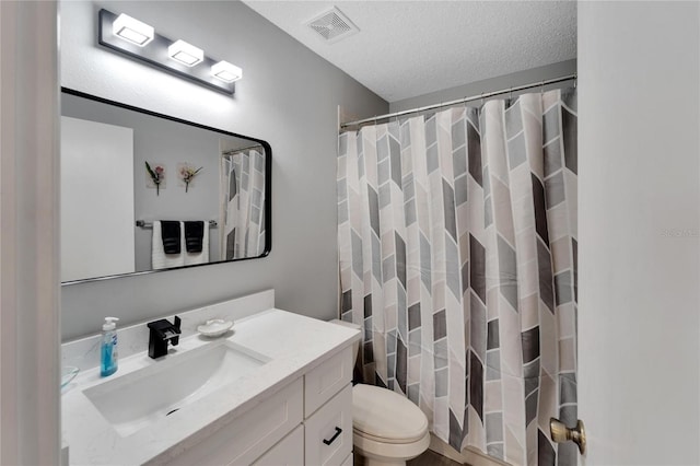 bathroom featuring a shower with curtain, vanity, a textured ceiling, and toilet