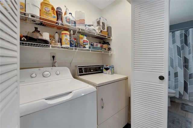 laundry room featuring washer and clothes dryer, wood-type flooring, and a textured ceiling