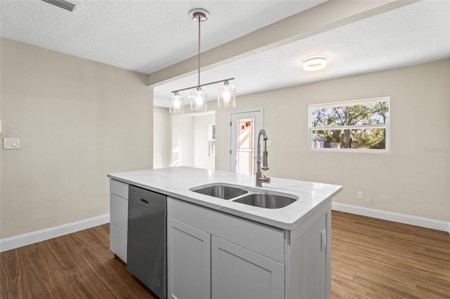 kitchen with stainless steel dishwasher, an island with sink, sink, and light stone counters