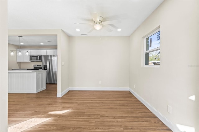 unfurnished room with ceiling fan and light hardwood / wood-style flooring