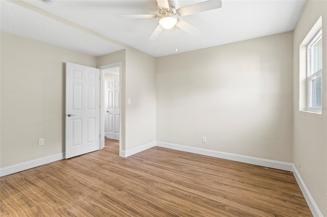 empty room with ceiling fan and light hardwood / wood-style floors