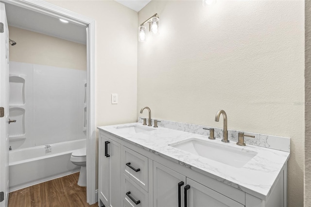 full bathroom with shower / bathtub combination, wood-type flooring, toilet, and vanity