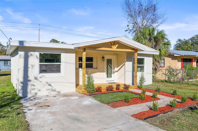 view of front facade featuring a front yard, fence, and stucco siding