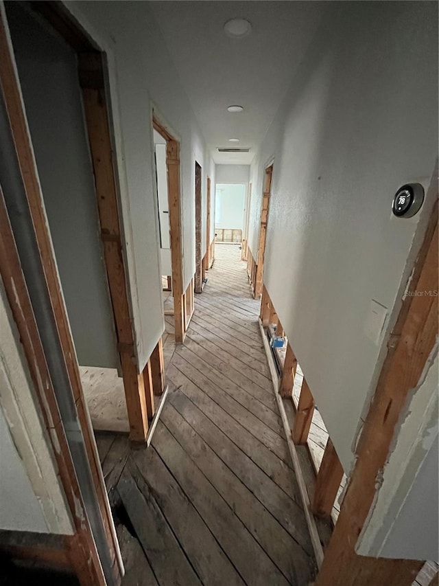 corridor with hardwood / wood-style flooring