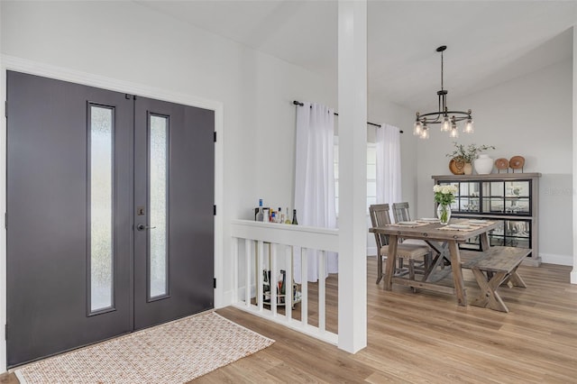 entryway with light hardwood / wood-style flooring and a chandelier