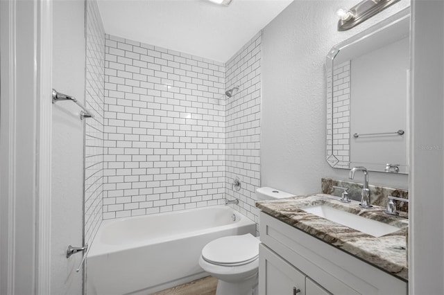 full bathroom featuring hardwood / wood-style flooring, vanity, toilet, and tiled shower / bath