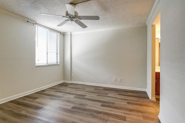 empty room featuring ceiling fan, wood-type flooring, ornamental molding, and a textured ceiling