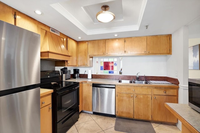 kitchen featuring sink, light tile patterned floors, a tray ceiling, stainless steel appliances, and custom range hood