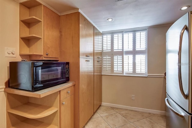 kitchen featuring stainless steel refrigerator, ornamental molding, and light tile patterned floors