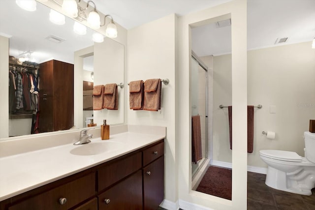 bathroom featuring tile patterned flooring, vanity, toilet, and walk in shower