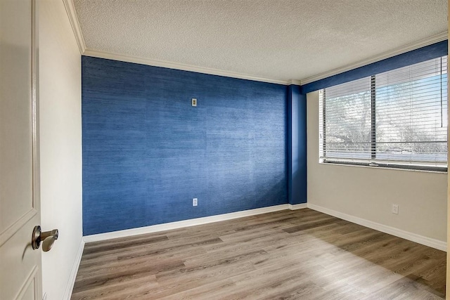 unfurnished room featuring crown molding, wood-type flooring, and a textured ceiling