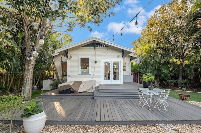 rear view of property featuring a wooden deck and french doors