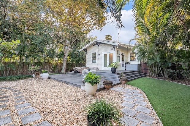 back of property featuring a yard, french doors, and a deck