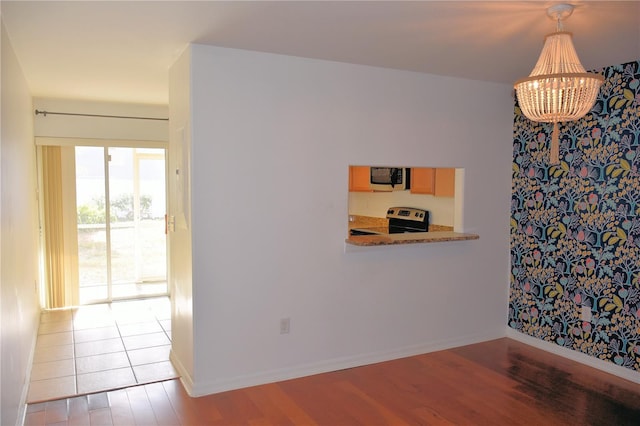 unfurnished dining area featuring a notable chandelier and light hardwood / wood-style floors