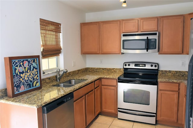 kitchen with stainless steel appliances, sink, light tile patterned floors, and light stone counters