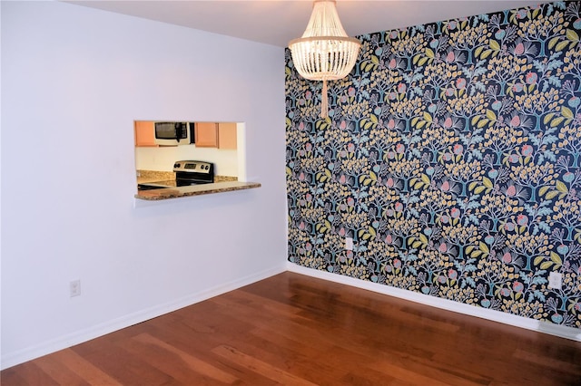 unfurnished dining area with a notable chandelier and hardwood / wood-style flooring