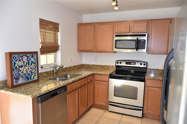 kitchen featuring light stone counters, sink, light tile patterned floors, and appliances with stainless steel finishes