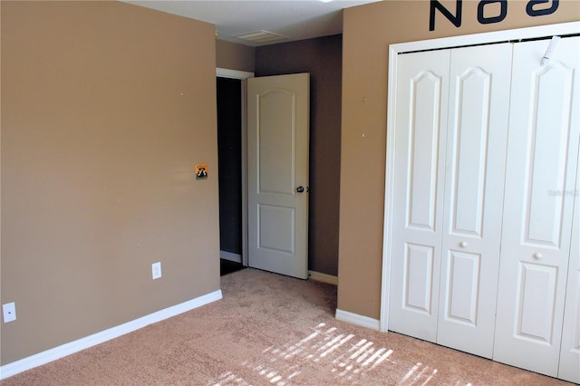 unfurnished bedroom featuring light colored carpet and a closet