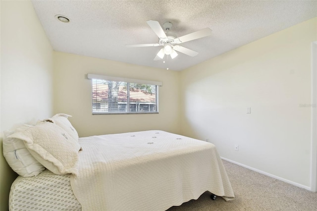 bedroom featuring ceiling fan, carpet floors, and a textured ceiling