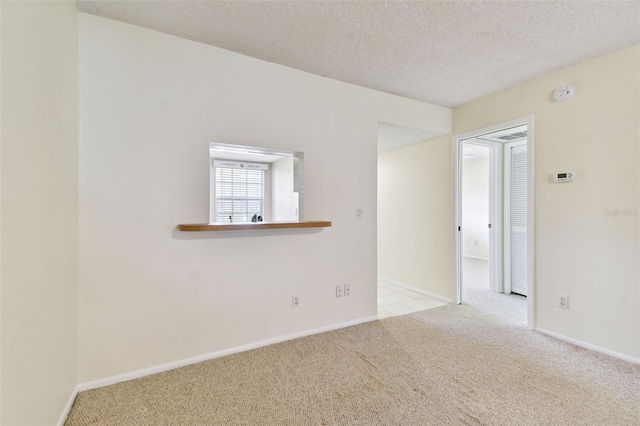 unfurnished room featuring light colored carpet and a textured ceiling