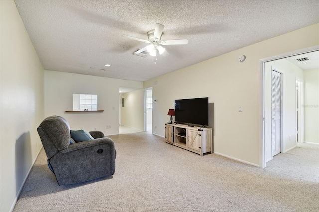 carpeted living room with a textured ceiling and ceiling fan