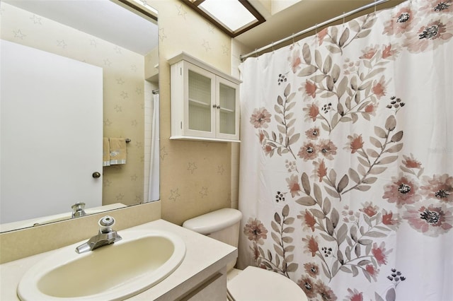 bathroom featuring curtained shower, vanity, and toilet