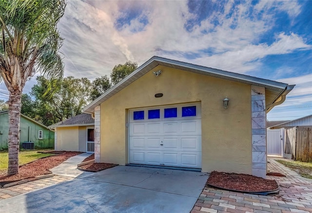 exterior space with central AC unit and a garage