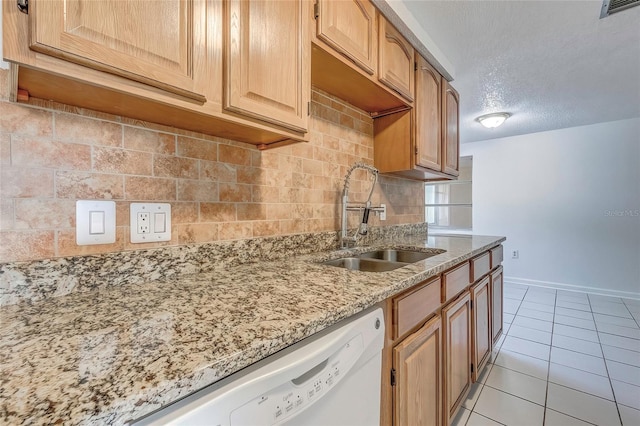 kitchen featuring light stone countertops, sink, a textured ceiling, decorative backsplash, and light tile patterned floors