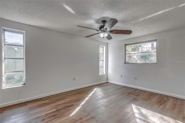 empty room featuring a textured ceiling, light hardwood / wood-style floors, and ceiling fan