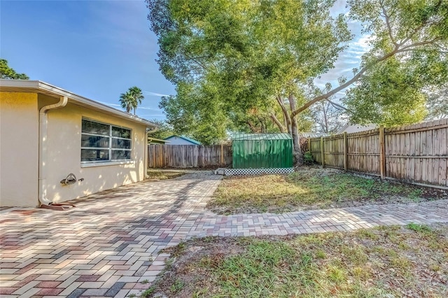 view of yard featuring a storage unit and a patio area