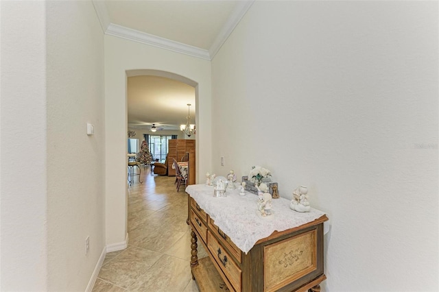 corridor with crown molding and an inviting chandelier