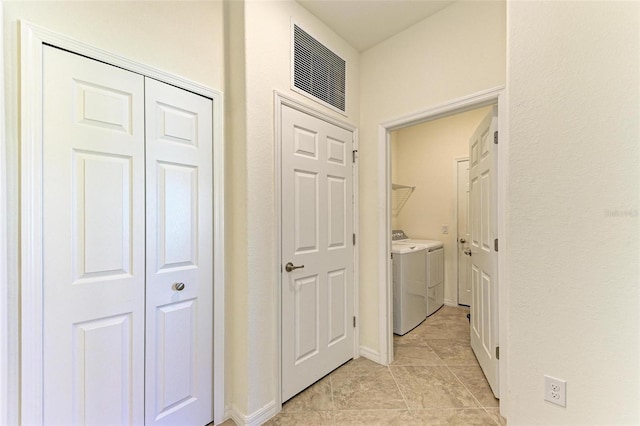 corridor with light tile patterned floors and washing machine and clothes dryer