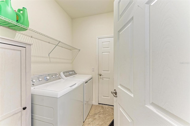 clothes washing area with light tile patterned floors and washing machine and dryer