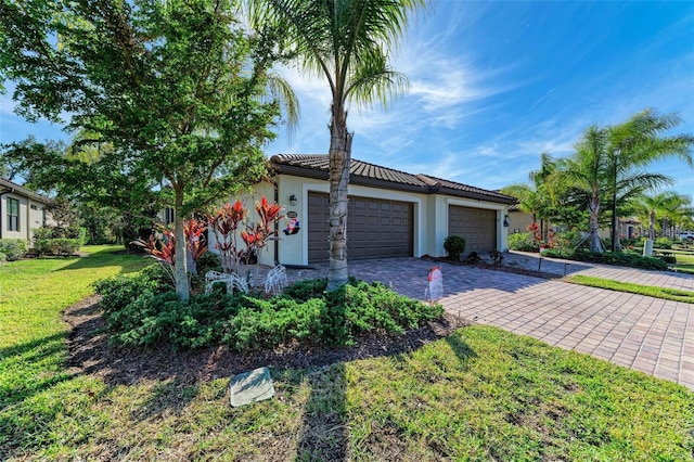 view of front of home with a garage and a front lawn