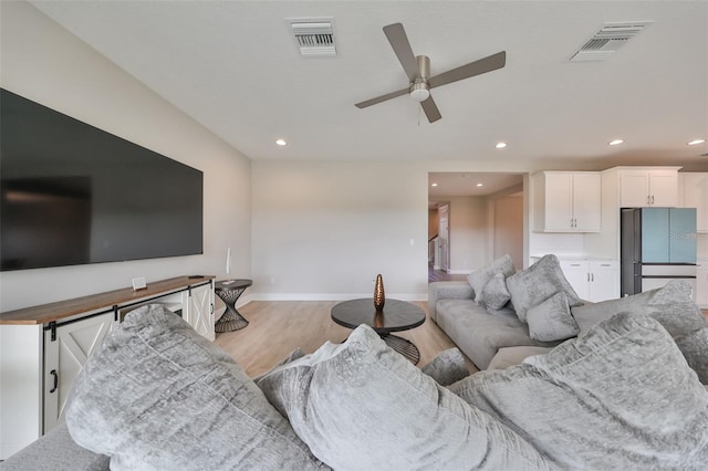 living area with light wood-style floors, stairs, visible vents, and recessed lighting