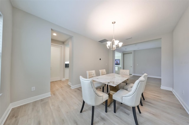 dining room featuring a notable chandelier, light wood-style flooring, and baseboards